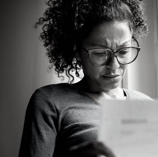 Woman with glasses studying legal document
